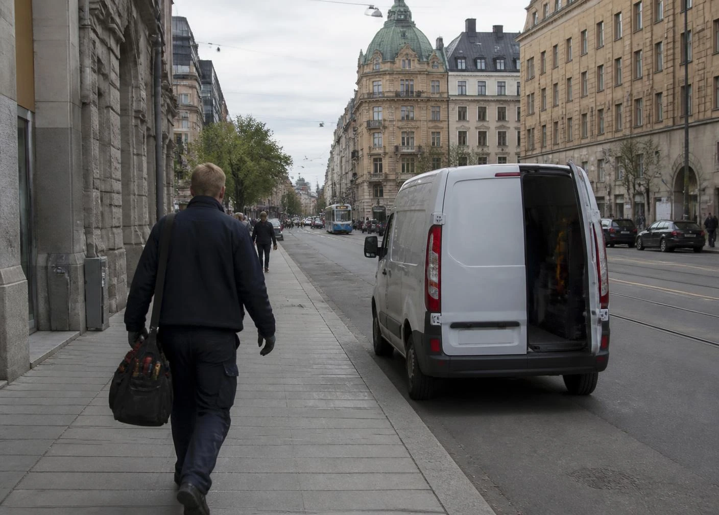 Servicemedarbetare på väg till nästa uppdrag vid sin servicebil i Stockholm